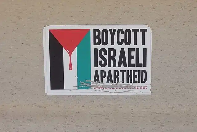 Sticker with Palestinian flag imagery altered to show dripping blood, alongside the words "Boycott Israeli Apartheid."