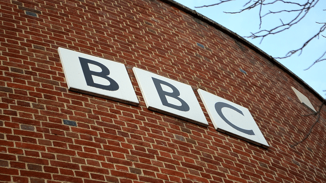BBC headquarters sign displayed on a brick building exterior.