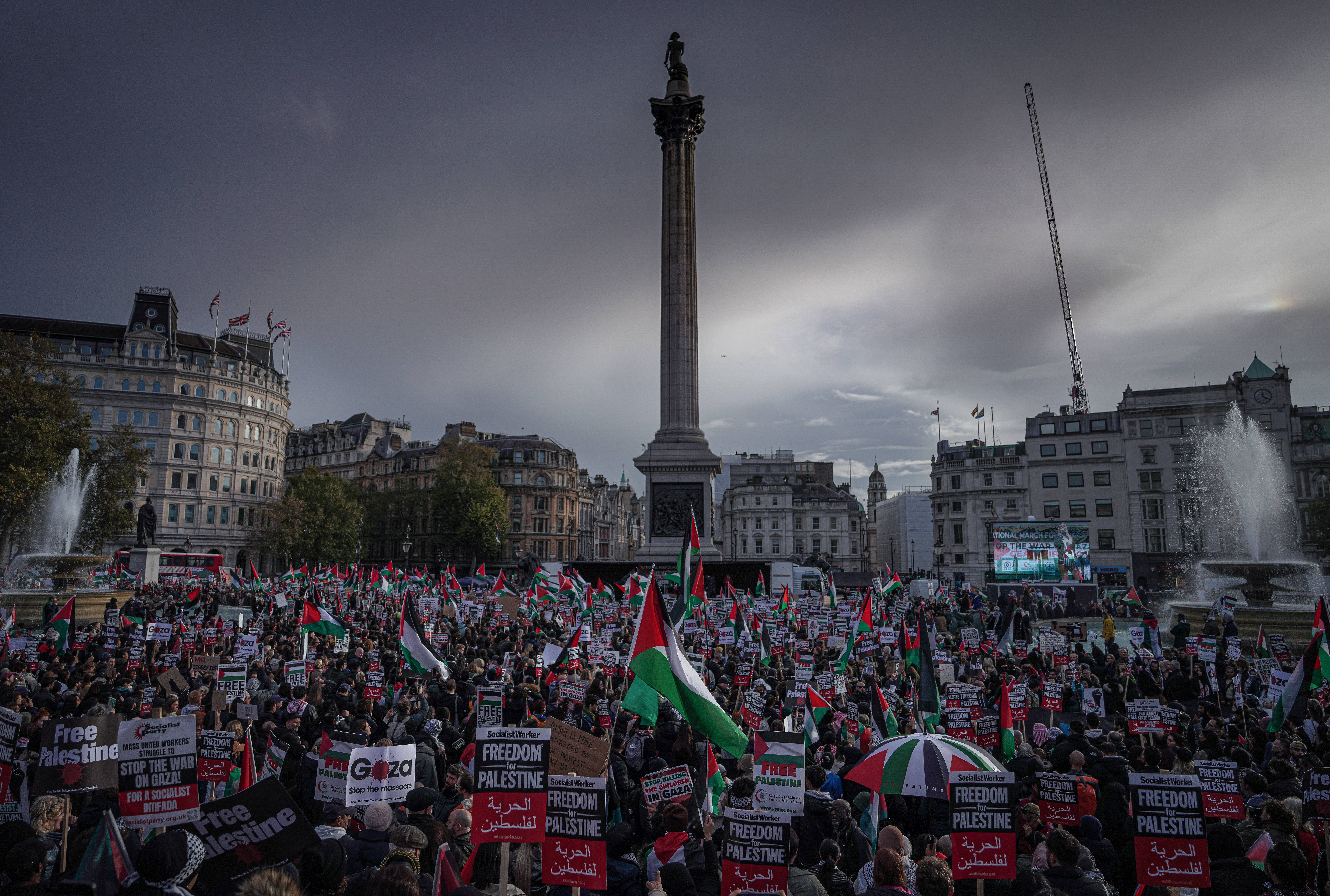Large pro-Palestinian protest fills Trafalgar Square in London, with demonstrators waving Palestinian flags and holding “Free Palestine” signs.