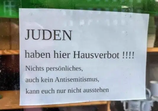 Sign in a German shop window declaring “Jews are banned here,” sparking outrage in Flensburg.