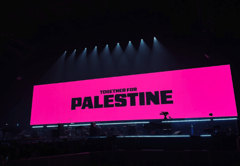 Bright pink screen at Wembley Arena displaying “Together for Palestine” before a sold-out anti-Israel concert.