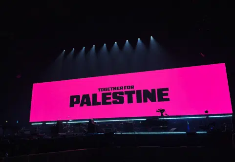 Bright pink screen at Wembley Arena displaying “Together for Palestine” before a sold-out anti-Israel concert.