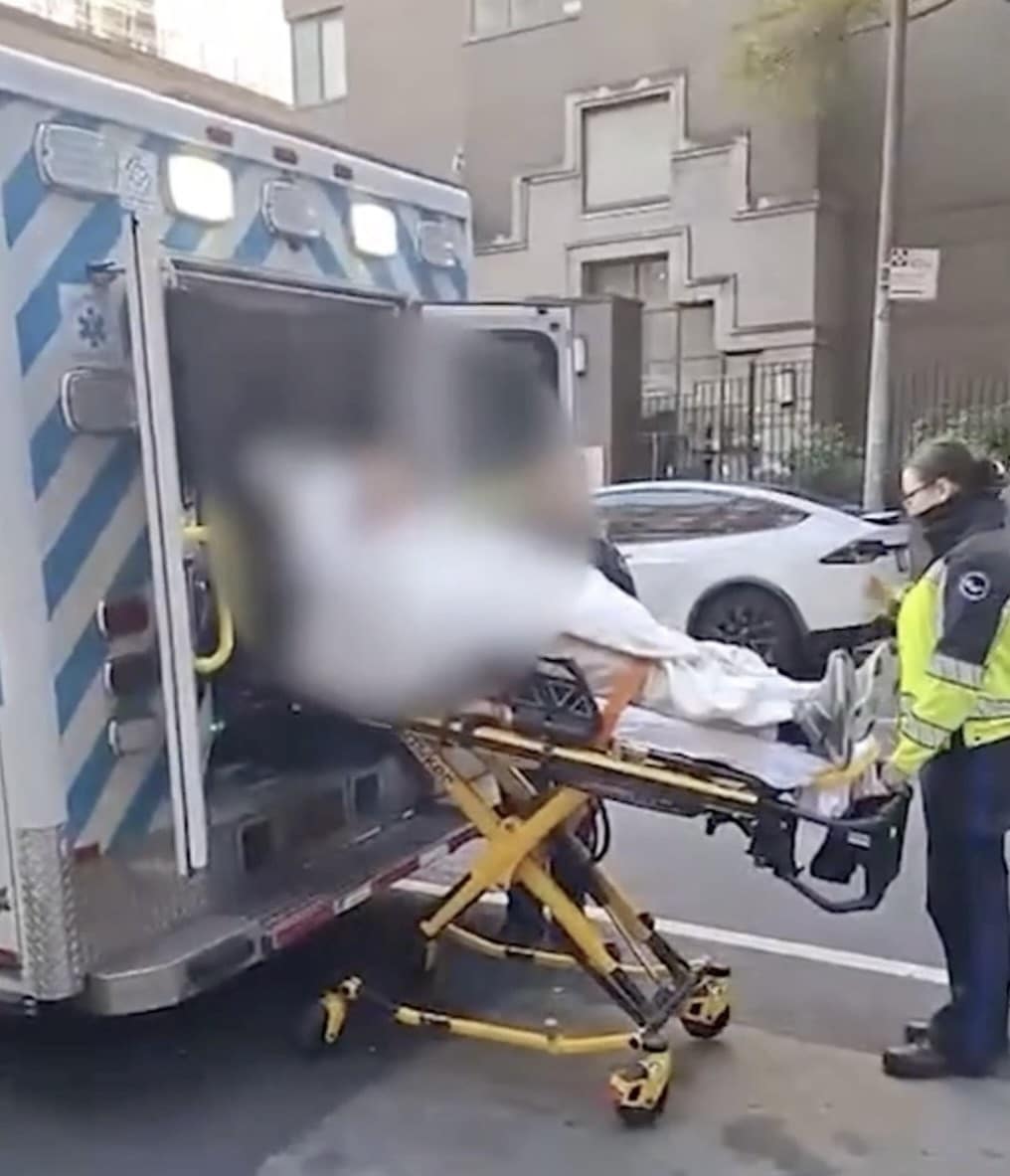 A paramedic assists an injured person being loaded into an ambulance on a New York City street following an attack.