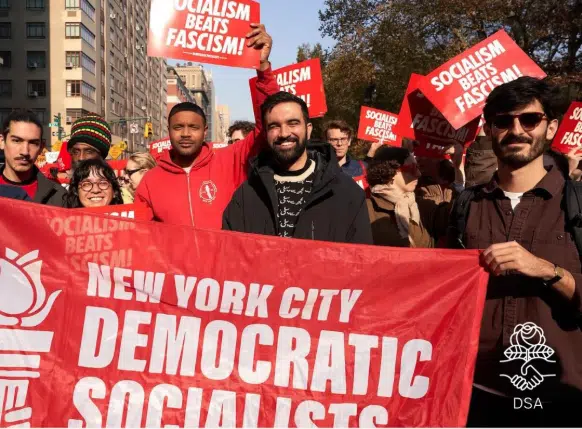 Zohran Mamdani stands among members of the Democratic Socialists of America at a New York City rally