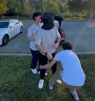 Students at a Virginia high school act out a mock kidnapping, covering a classmate’s head and forcing him toward a car trunk.