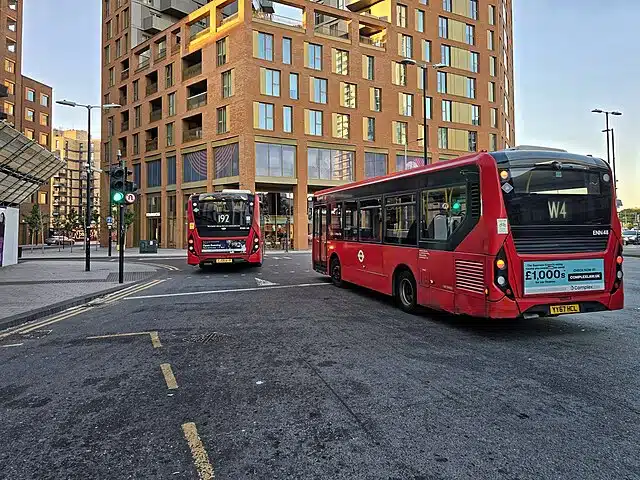 Two red London buses drive near Tottenham Hale Station in north London.