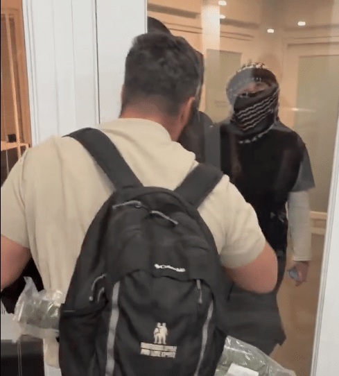 A masked anti-Israel protester confronts a man blocking the door of a Toronto venue during an SSI event with IDF veterans.