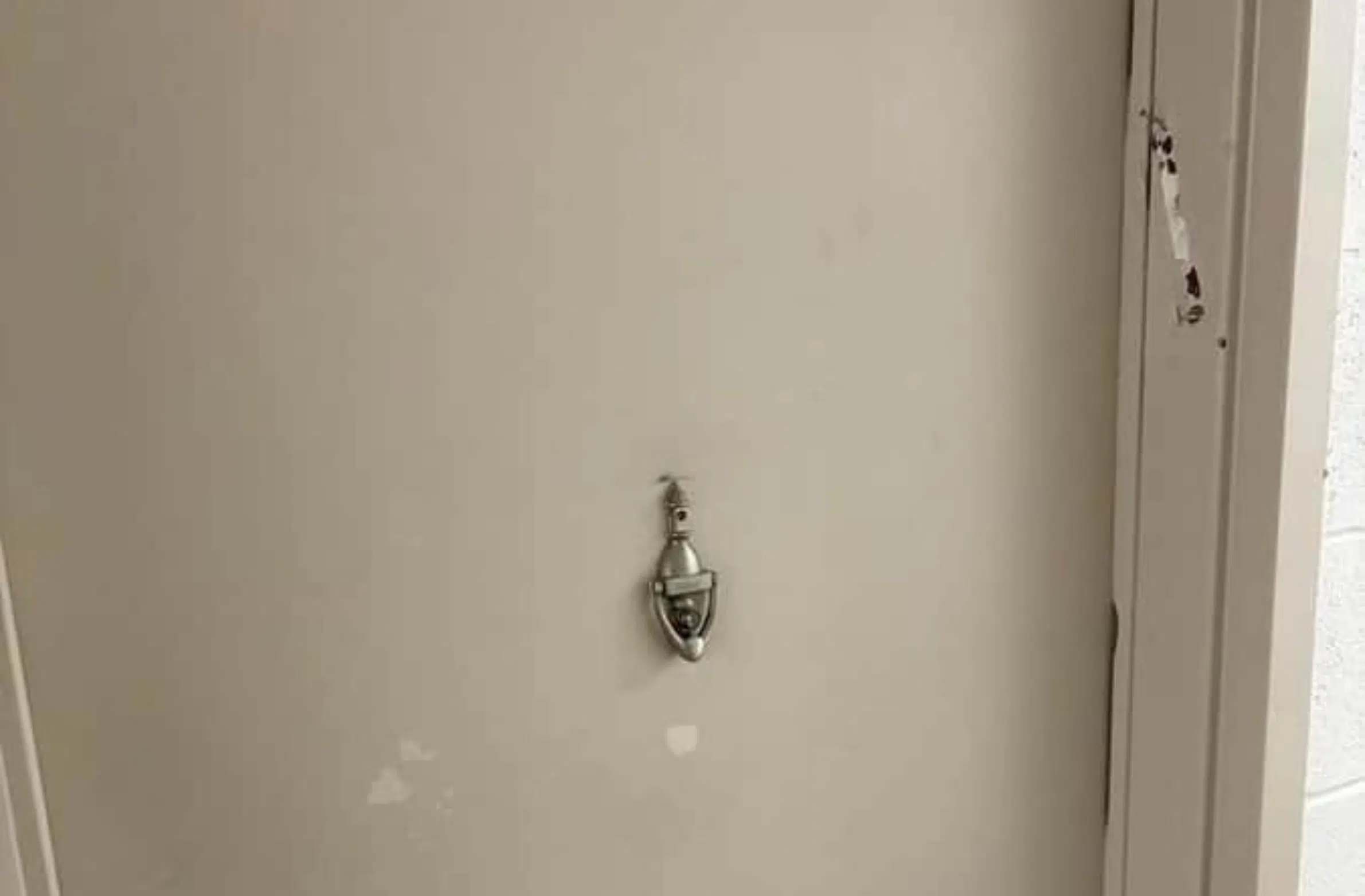 Ripped mezuzah casing removed from a doorframe at a residential building.