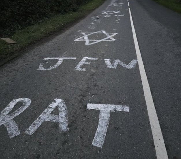 Antisemitic graffiti painted on a rural road in County Louth, Ireland, including a Star of David and the words “Jew” and “Rat.”