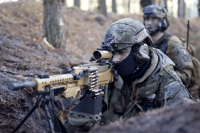 Illustrative image of German Bundeswehr paratroopers during a military training exercise, operating in a wooded environment.