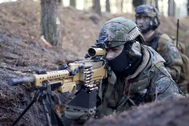 Illustrative image of German Bundeswehr paratroopers during a military training exercise, operating in a wooded environment.