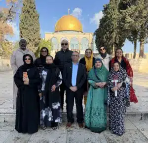 Members of the AMMWEC–CAM delegation stand together at the Temple Mount in Jerusalem, with the Dome of the Rock visible behind them.