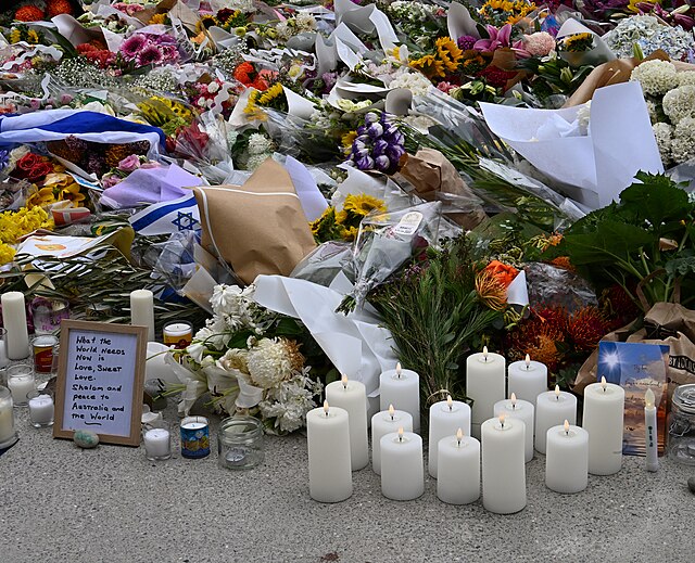 Memorial candles, flowers, and Israeli flags laid in tribute to victims of the antisemitic Bondi Beach attack.