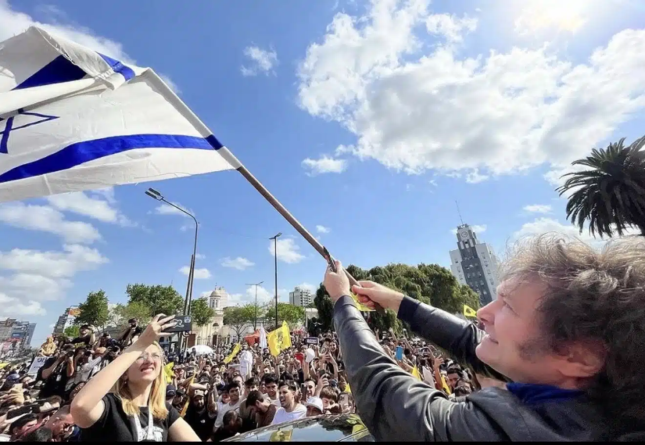 Argentine President Javier Milei waves an Israeli flag during a public rally in Argentina.