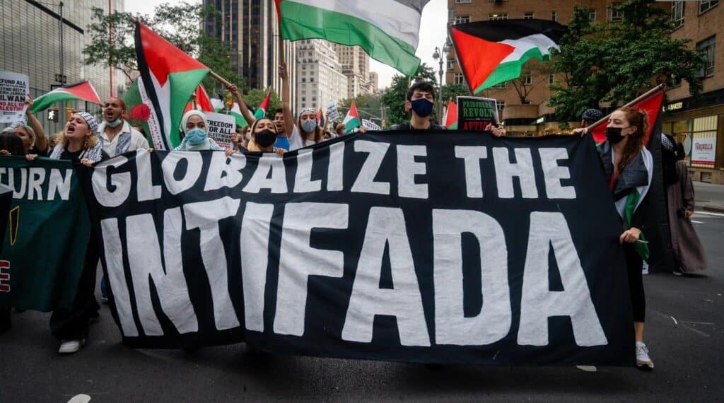 Protesters hold a large banner reading “Globalize the Intifada” during an anti-Israel demonstration.