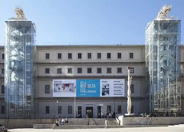 Exterior view of the Museo Nacional Centro de Arte Reina Sofía in Madrid, Spain, featuring its glass elevator towers and main entrance.