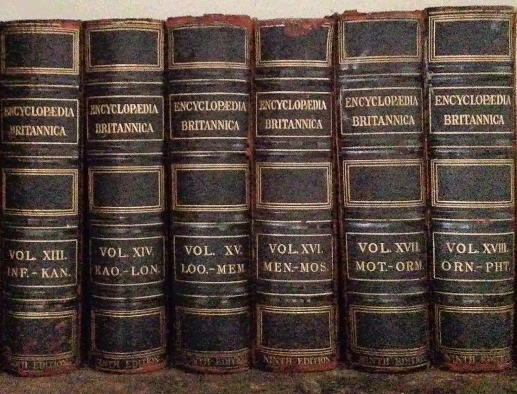 A row of vintage Encyclopedia Britannica volumes on a bookshelf
