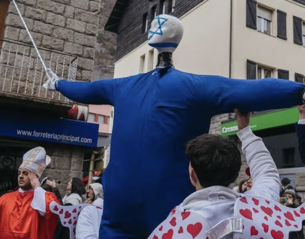 Carnival participants in Encamp, Andorra hold up an effigy painted with the Israeli flag during a mock trial and staged execution at a public festival.