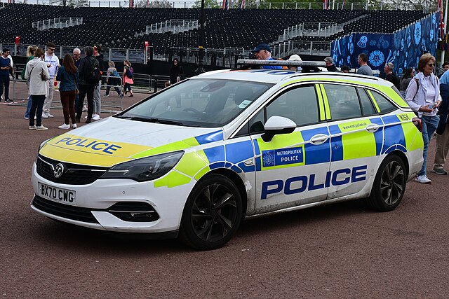 Marked Metropolitan Police Service patrol car parked at a public event in London, with people visible in the background.
