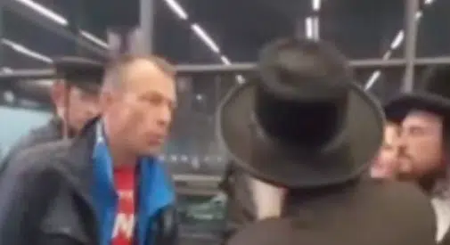 A man confronts a group of ultra-Orthodox Jewish travelers inside Krakow Airport, as seen in a video documenting an antisemitic incident while they waited to board a flight to Israel.