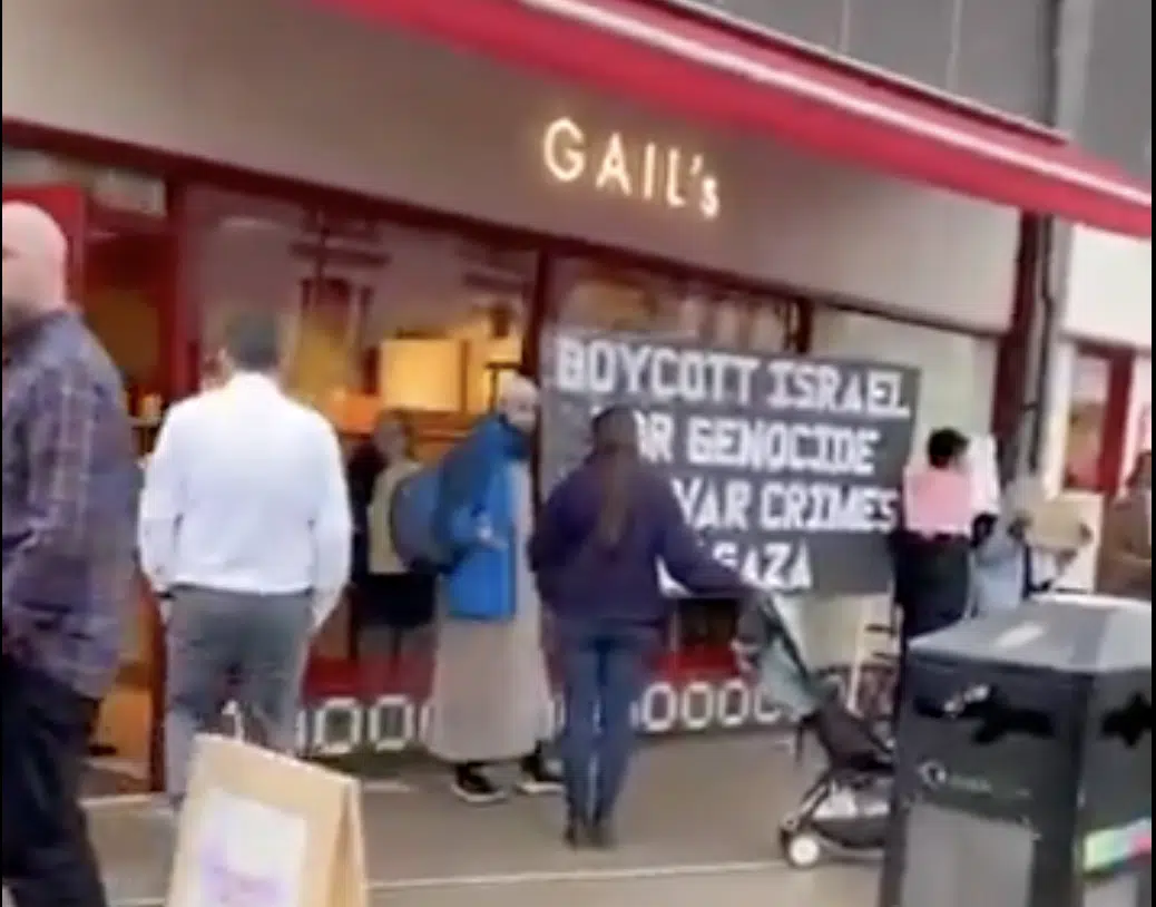 Protesters stand outside a newly-opened Gail’s Bakery branch in north London holding a large sign reading “Boycott Israel For Genocide And War Crimes in Gaza.”