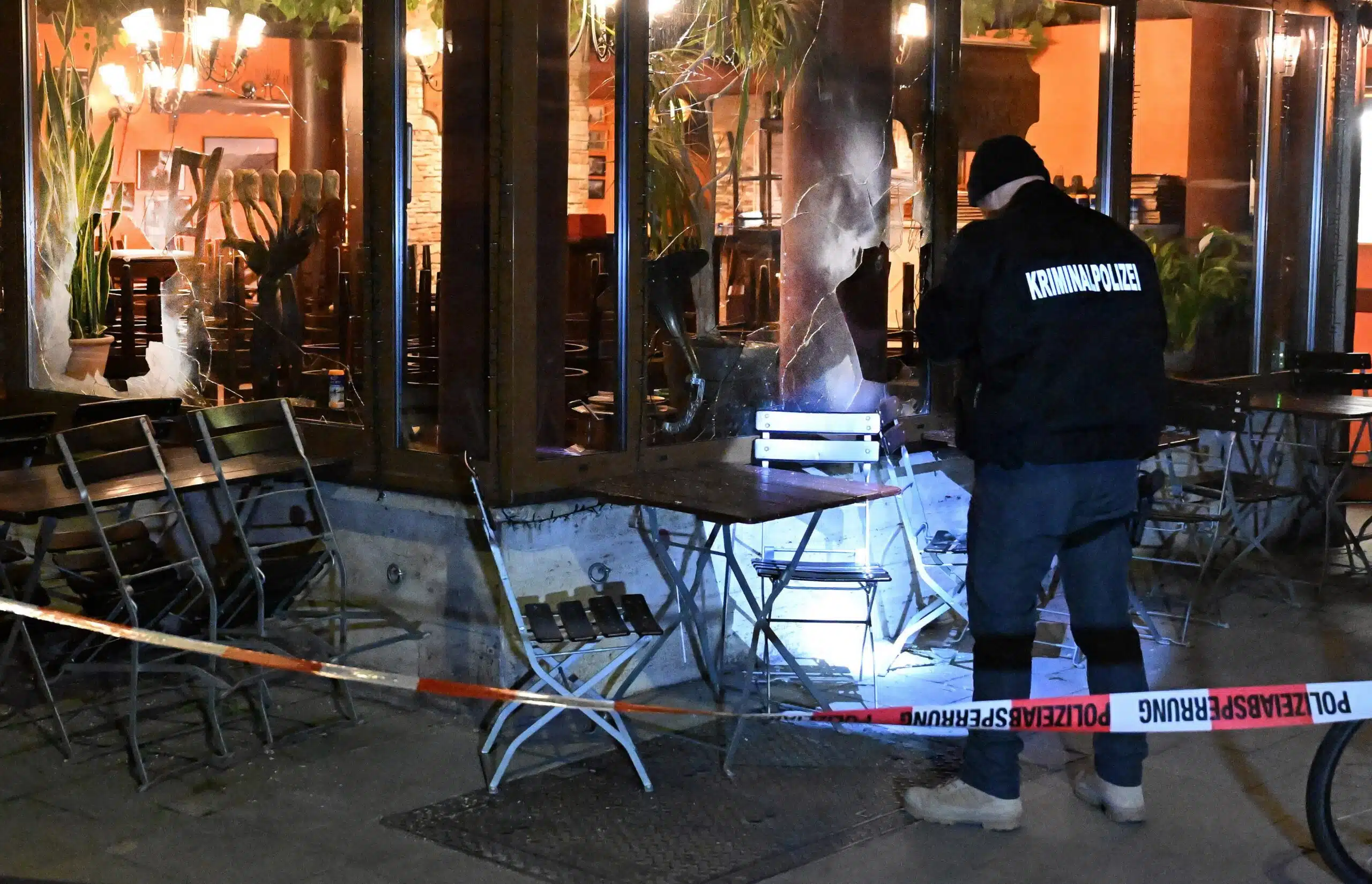 Police tape visible outside Eclipse Grillbar in Munich after an overnight explosion damaged the Israeli restaurant’s windows.
