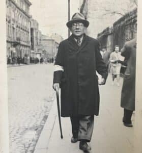 Black-and-white photograph of Linda Margolin Royal’s great-grandfather walking in the Warsaw Ghetto wearing a Jewish armband under Nazi rule.