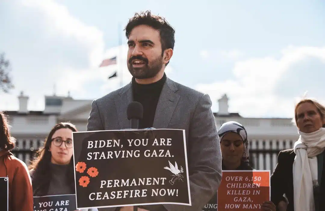 Zohran Mamdani speaks at a pro-Palestinian demonstration outside the White House while holding a sign calling for a permanent ceasefire in Gaza.