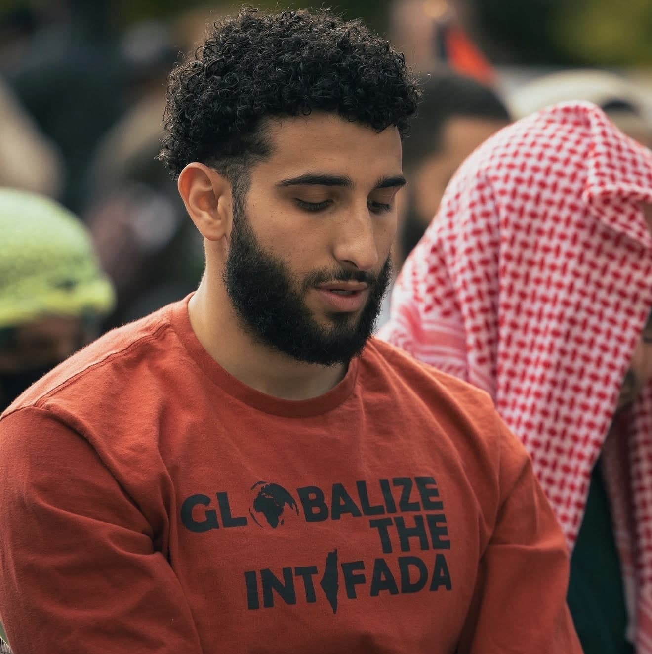 An anti-Israel activist wearing a red “Globalize the Intifada” sweatshirt at a public demonstration