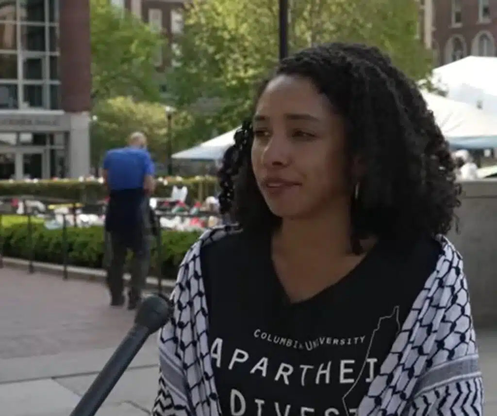 Darializa Avila Chevalier speaks on Columbia University campus while wearing a keffiyeh and a Columbia Apartheid Divest shirt.