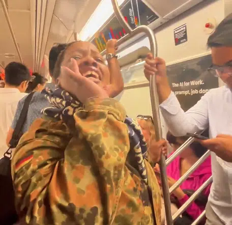 Woman aboard a Manhattan subway train during an antisemitic incident targeting an Orthodox Jewish passenger.
