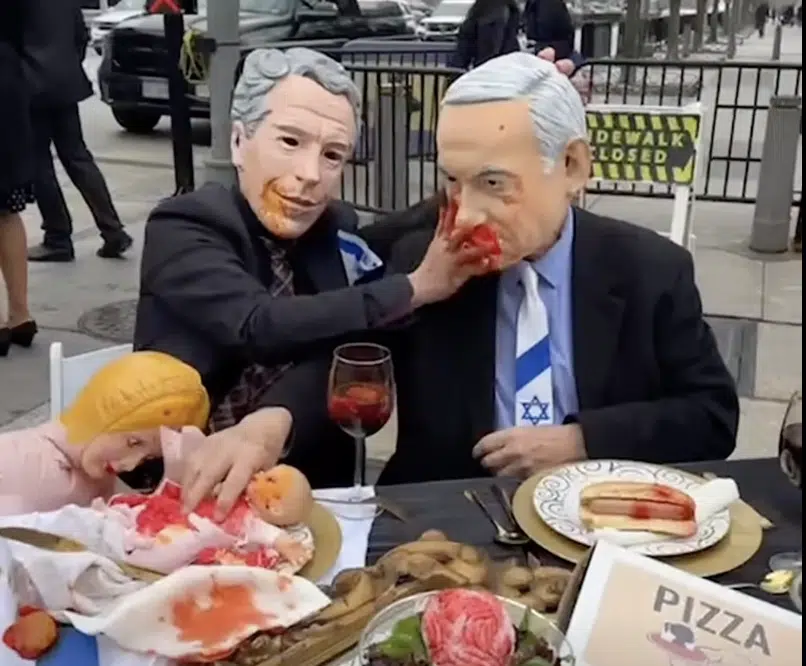 Anti-Israel installation in Washington, D.C., depicting masked figures resembling Benjamin Netanyahu and U.S. President Joe Biden consuming a child's body, invoking blood libel imagery.