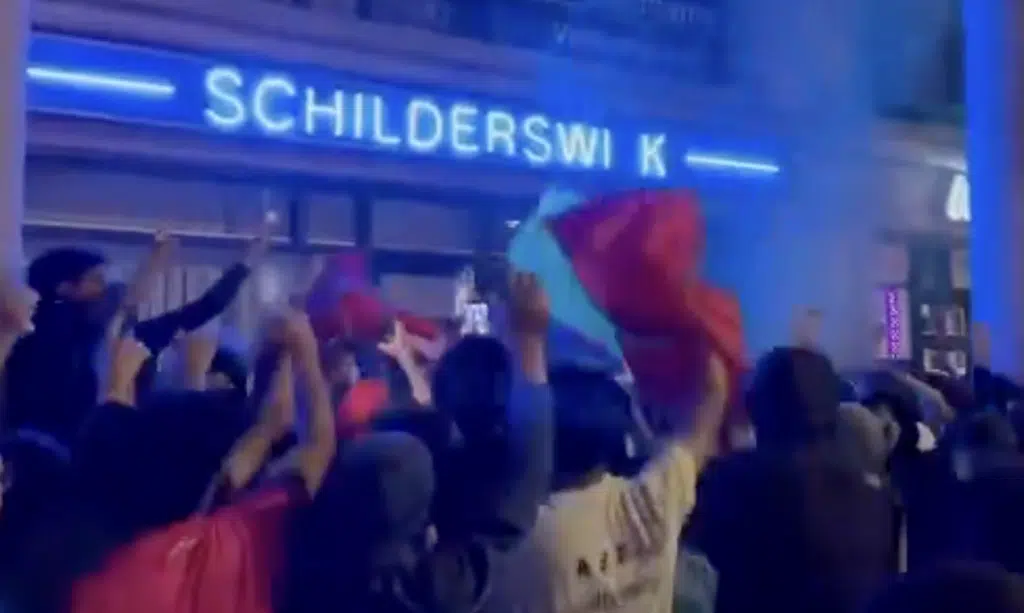 Crowd of Morocco supporters wave Moroccan and Palestinian flags in The Hague after Morocco's World Cup defeat, where some were filmed chanting an antisemitic slogan outside a health clinic.