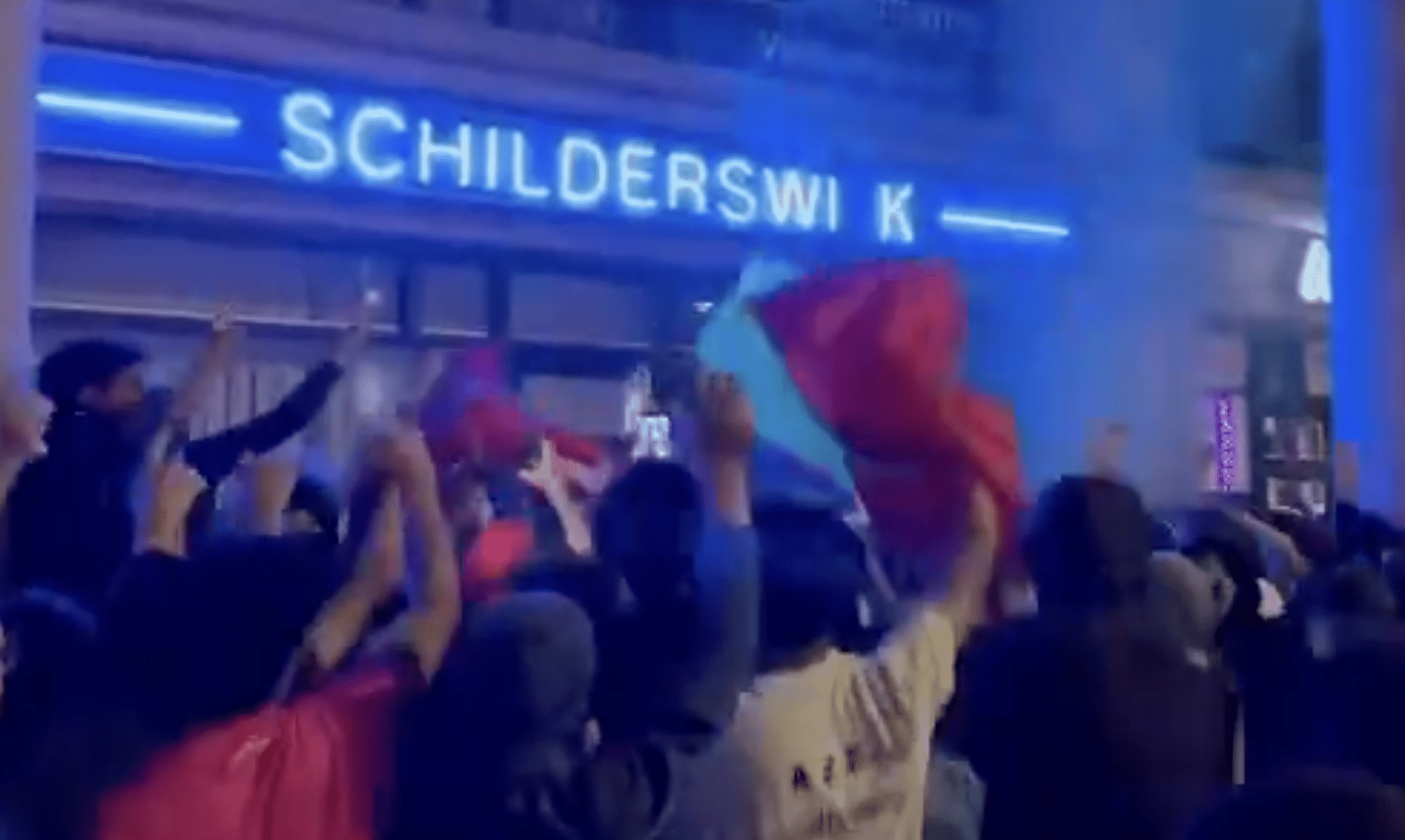 Crowd of Morocco supporters wave Moroccan and Palestinian flags in The Hague after Morocco's World Cup defeat, where some were filmed chanting an antisemitic slogan outside a health clinic.