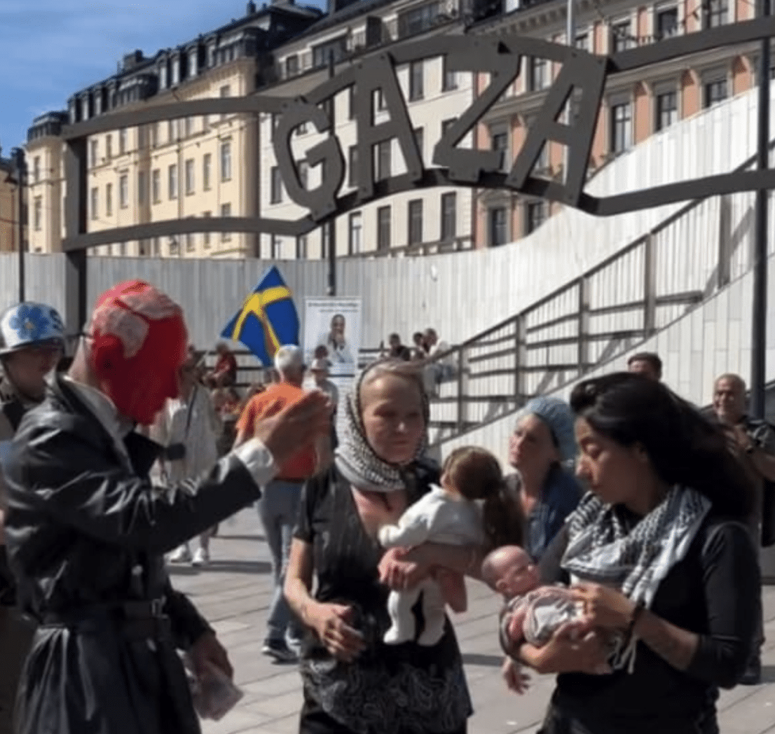 Anti-Israel demonstrators stage a performance beneath a mock Auschwitz entrance gate labeled "Gaza" during a protest in central Stockholm, Sweden, July 11, 2026.