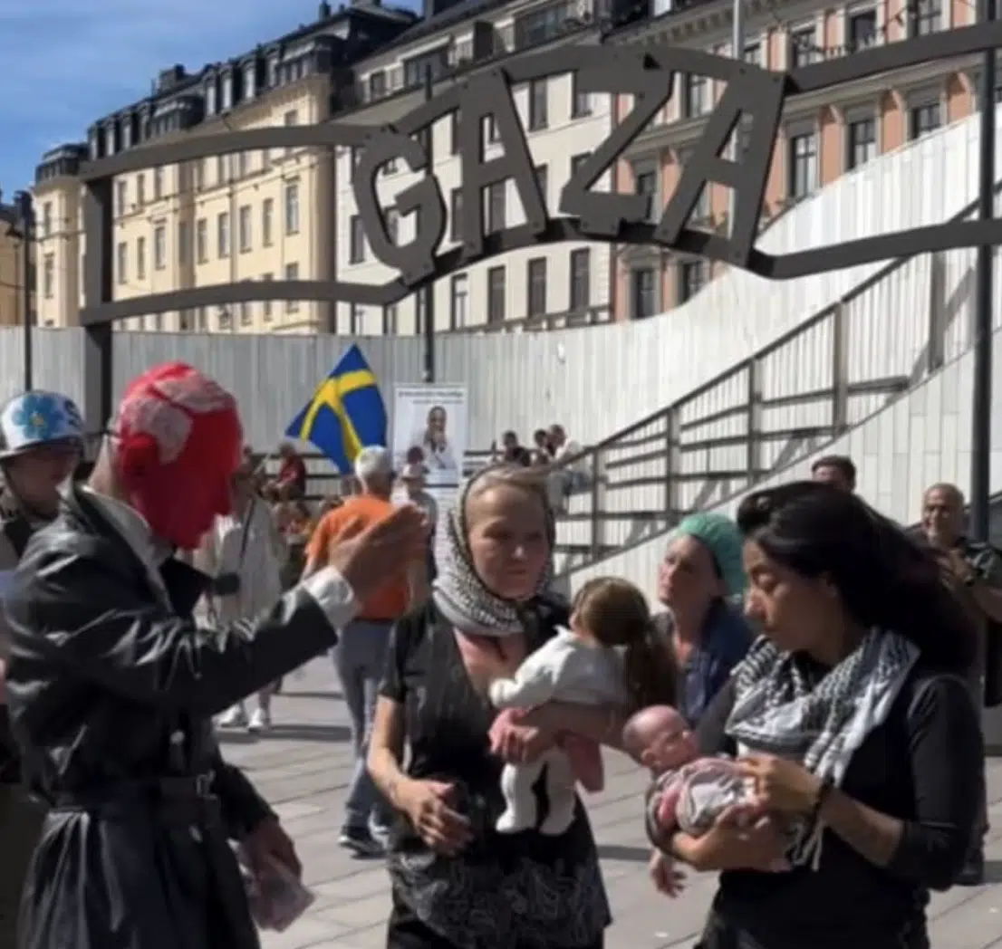 Anti-Israel demonstrators stage a performance beneath a mock Auschwitz entrance gate labeled "Gaza" during a protest in central Stockholm, Sweden, July 11, 2026.
