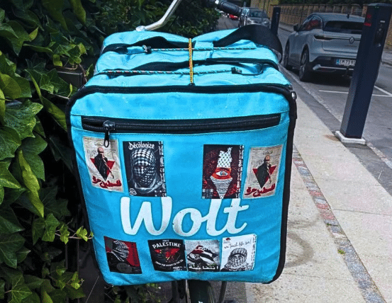 Wolt delivery bag in Copenhagen displaying multiple Hamas-related and pro-Palestinian propaganda stickers, including the red Hamas triangle symbol.