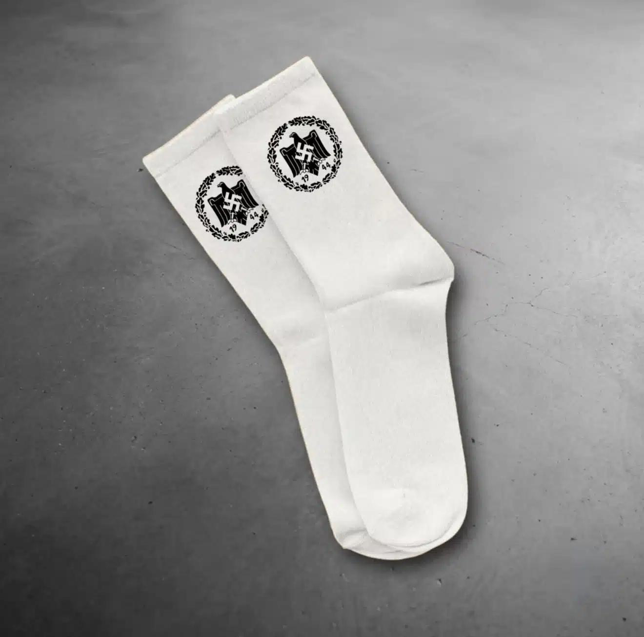 White socks displayed with a black Nazi-era eagle-and-swastika emblem marked "1944," part of an Instagram product listing that was recommended to a CAM account before Meta removed it.
