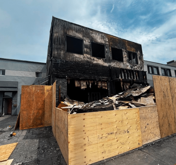 Fire-damaged Nöam Restaurant in Montreal after a suspected arson, with the charred building boarded off.