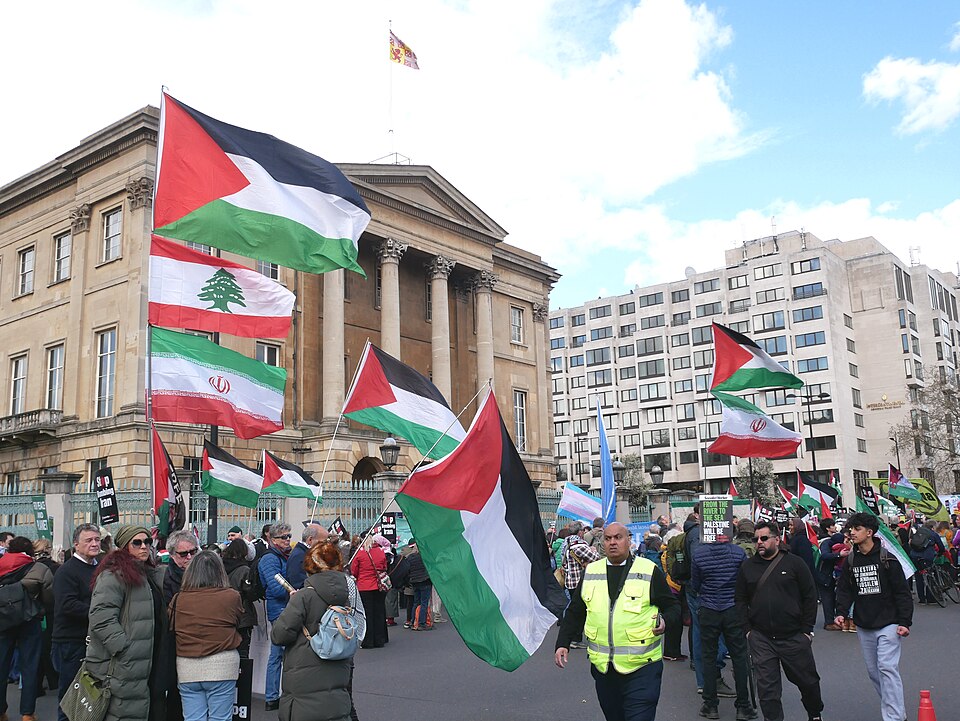 Protesters carry Palestinian flags alongside Lebanese and Iranian flags at a London march.
