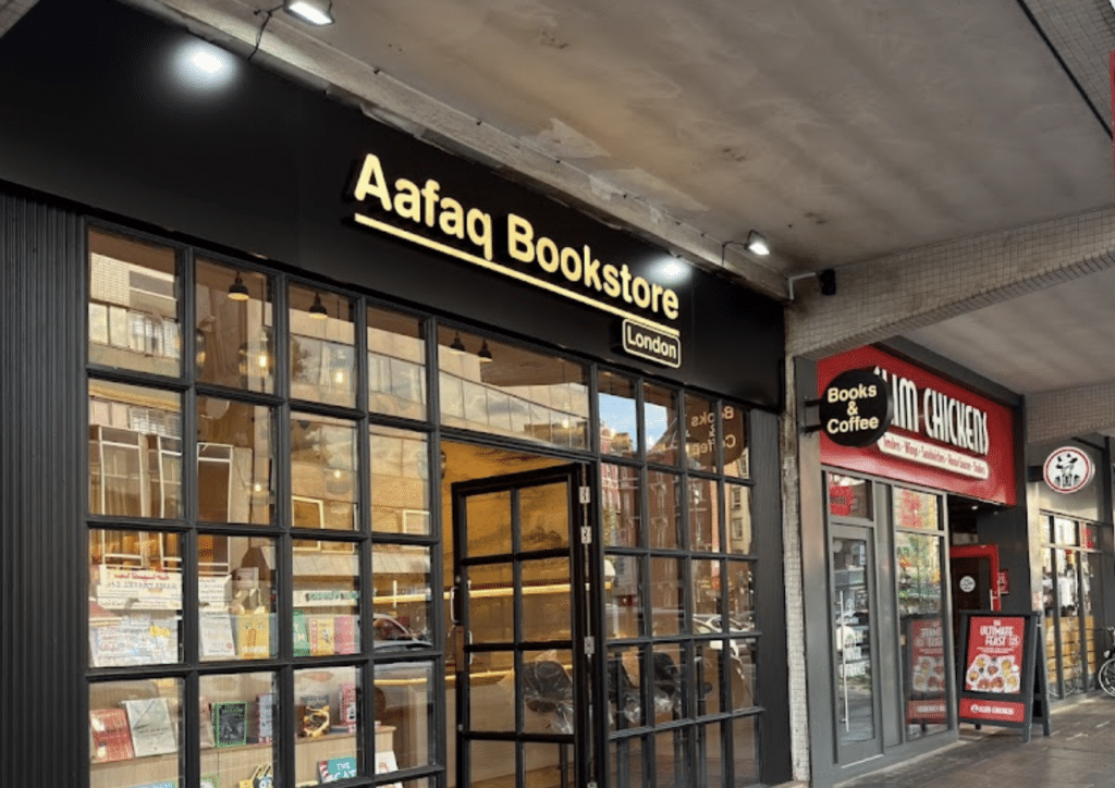 Exterior of Aafaq Bookstore in London, with its illuminated sign above the glass-fronted entrance.