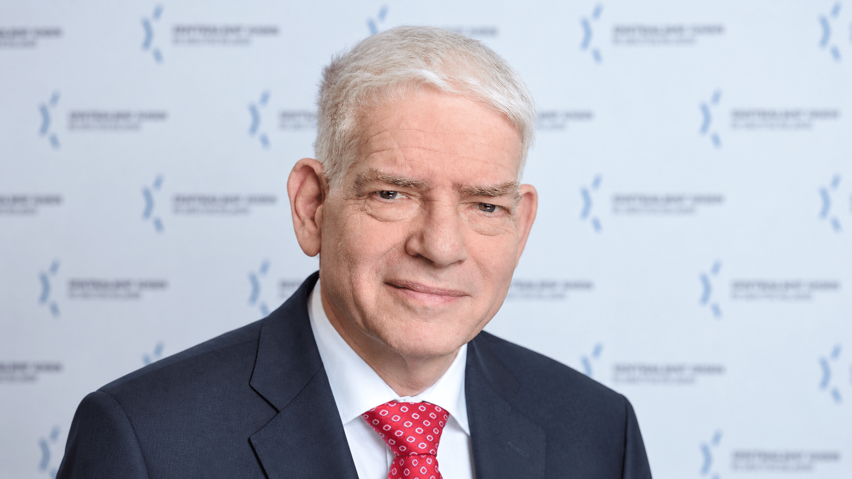 osef Schuster, President of the Central Council of Jews in Germany, wearing a dark suit and red tie.