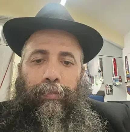 Milan Chabad Rabbi Tzemach Mizrahi wearing a black hat and jacket.