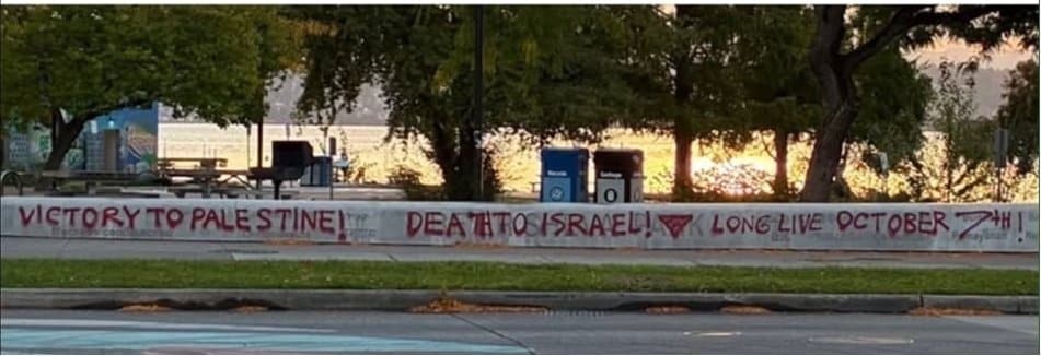 Red graffiti reading “Victory to Palestine,” “Death to Israel,” and “Long live October 7th,” with an inverted triangle, on a concrete wall.
