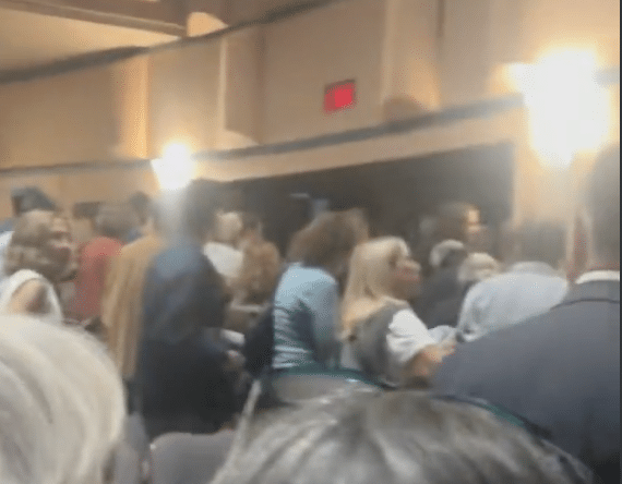 Audience members standing near an exit inside Northwestern University’s Cahn Auditorium.
