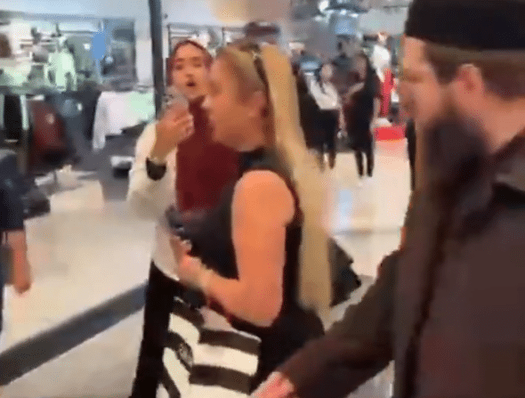 Israeli-Turkish influencer Kloyda Medina Halfon, wearing a black sleeveless top, is escorted through Istanbul's Istinyepark mall amid a confrontation with pro-Palestinian protesters.